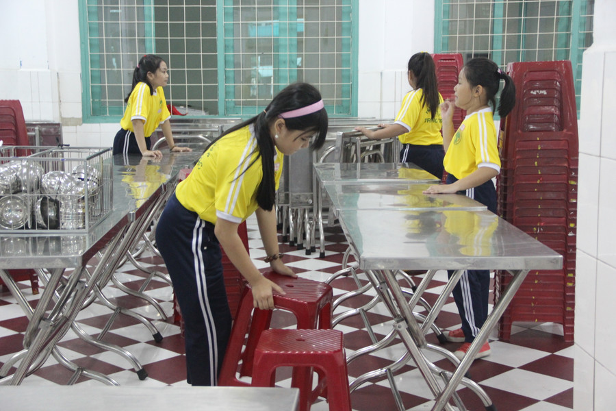 Học sinh lớp 5 hỗ trợ việc chuẩn bị bàn, ghế cho bữa trưa