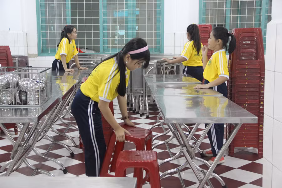 Học sinh lớp 5 hỗ trợ việc chuẩn bị bàn, ghế cho bữa trưa