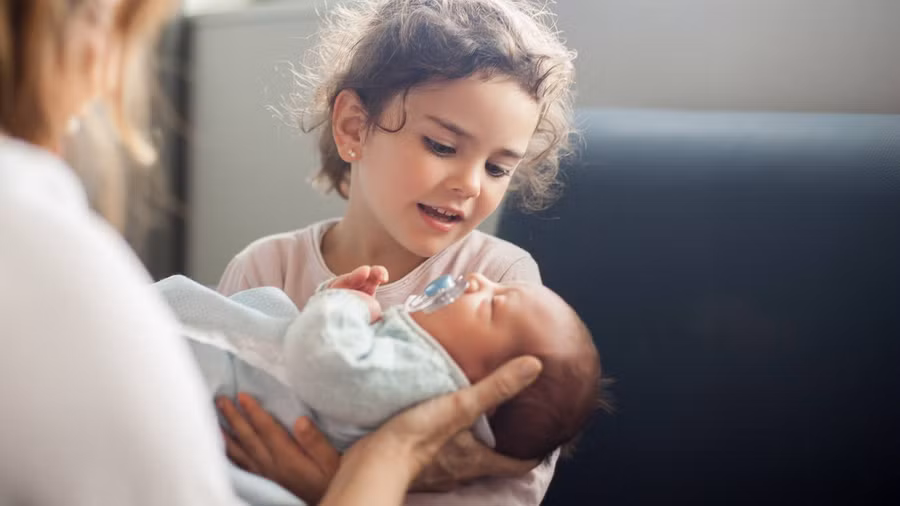 Cha mẹ nên để trẻ tham gia vào quá trình chăm sóc em bé.