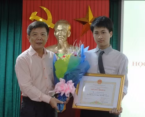 Ông Nguyễn Hữu Hoài tặng bằng khen và chúc mừng học sinh Nguyễn Thế Quỳnh sau khi giành HCB Olympic Vật lý Châu Á năm 2017. Ảnh: Vĩnh Quý.