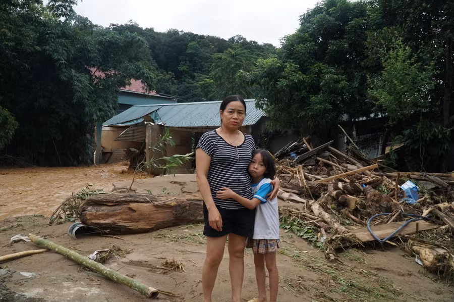 Cô La Thị Vân đứng trước ngôi nhà mới nay đã tan hoang vì lũ.