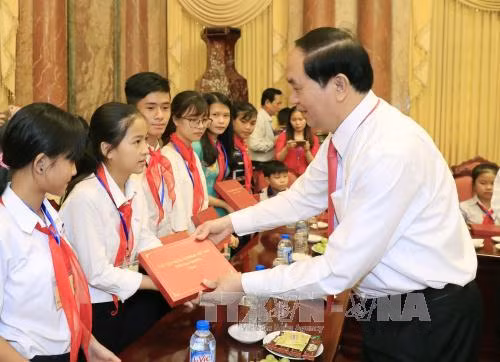 Chủ tịch nước Trần Đại Quang tặng quà các em học sinh nghèo hiếu học, học giỏi, trẻ em có hoàn cảnh đặc biệt, khó khăn. Ảnh: TTXVN