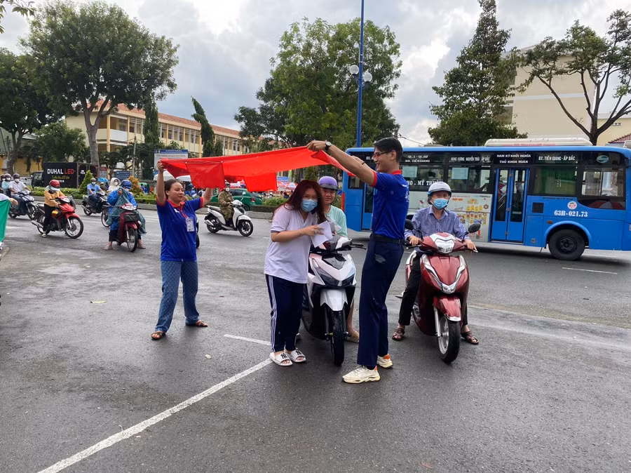 Tình nguyện viên che mưa cho thí sinh tỉnh Tiền Giang.