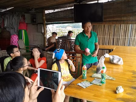 Một nghệ nhân đang hướng dẫn cách làm trà sen cho các em nhỏ.