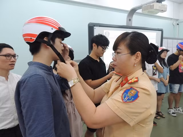 Các sinh viên nước ngoài được tặng nón bảo hiểm đạt chuẩn tại buổi nói chuyện