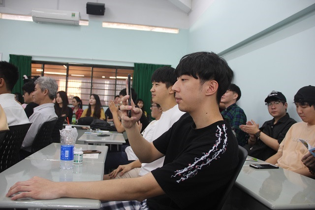 Một sinh viên dùng điện thoại ghi lại hướng dẫn của các chiến sĩ công an giao thông trong buổi nói chuyện