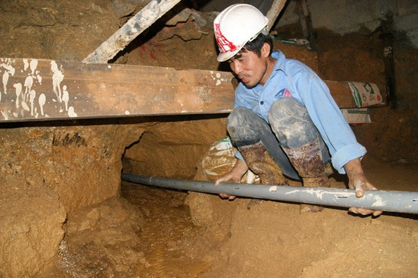 Mũi khoan này rộng khoảng 7cm, dài 60m, vị trí khoan cách nền hầm 50cm. Chiều 20/12, nước từ khoang hầm các công nhân mắc kẹt xối mạnh ra ngoài. Trong ảnh: các công nhân đang lắp đạt đường ống nhựa (có khoan các lỗ nhỏ quanh ống để thu nước) để dẫn nước ra ngoài, đề phòng nước tiếp tục làm xói lở đất. Tận thấy những ngách hầm giải cứu 12 nạn nhân mắc kẹt