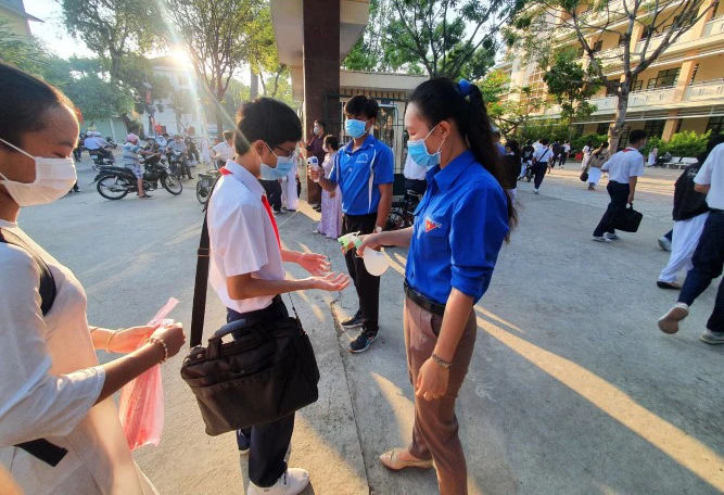 Học sinh lớp 9 tại TP Mỹ Tho (Tiền Giang) đến trường ôn thi được đo nhiệt độ và sát khuẩn tay 