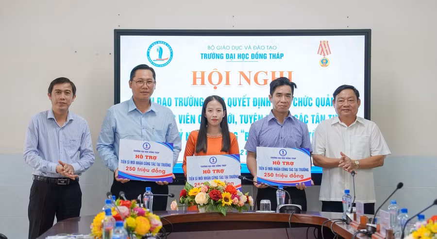 TS Trương Tấn Đạt, Chủ tịch Hội đồng trường (trái) và TS Hồ Văn Thống, Hiệu trưởng trao gói hỗ trợ viên chức tuyển dụng mới có học vị tiến sĩ.