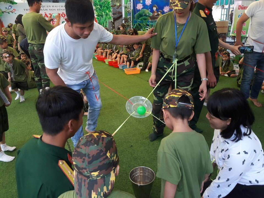 Trò chơi vận động với bóng, có cả sự tham gia của phụ huynh, giúp bé rèn luyện sự khéo léo, cẩn thận