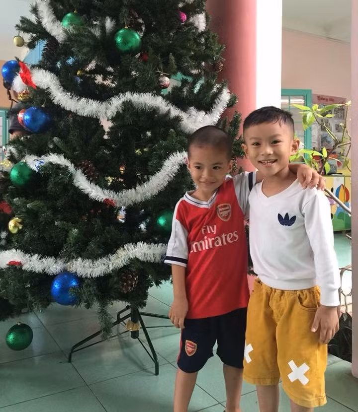 Các em nhỏ thích thú chụp hình với cây thông được trang trí tại trường mầm non (ảnh minh họa)