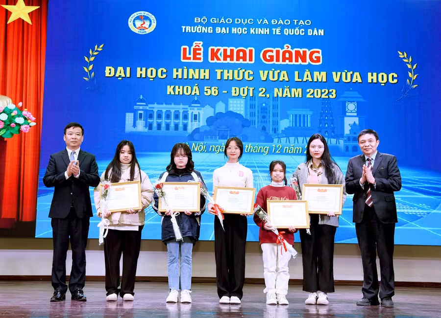 PGS.TS Bùi Huy Nhượng - Phó Hiệu trưởng và PGS.TS Phạm Quang - Trưởng khoa Đại học Tại chức trao giấy khen và tặng hoa chúc mừng cho các tân sinh viên.