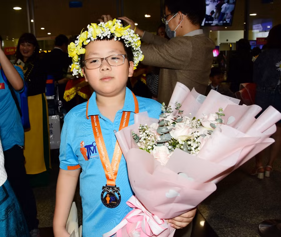 Học sinh Nguyễn Minh Phú, lớp 5Q1, nhận hoa chúc mừng khi trở về từ cuộc thi Toán quốc tế ITMC.