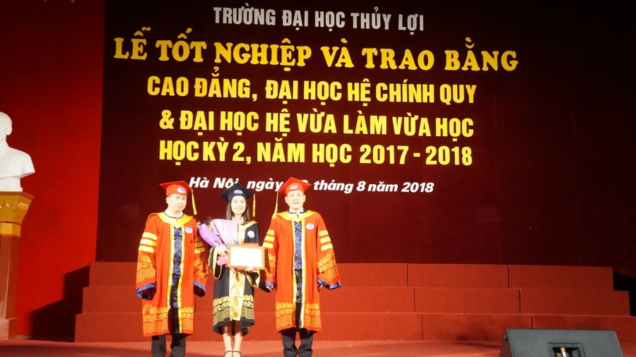 GS.TS Nguyễn Trung Việt và PGS.TS Nguyễn Tuấn Anh trao giấy khen của Hiệu trưởng Trường ĐH Thủy Lợi cho cử nhân Nguyễn Thùy Linh (56K – TN) – thủ khoa xuất sắc, học kỳ 2 năm học 2017 – 2018.