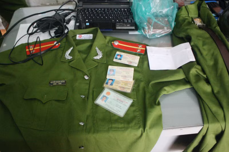 Bộ đồ trang phục công an, giấy tờ giả và ma túy đá bị công an thu giữ tại phòng của Hưng. Ảnh: Vũ Hội