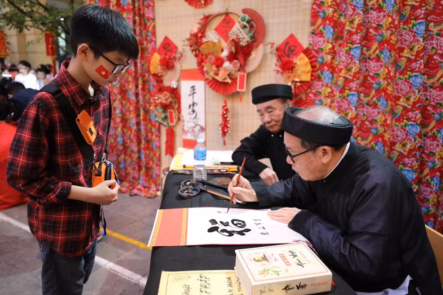 Học sinh Trường THCS Trưng Vương thích thú tìm hiểu câu đối Tết. Ảnh: TG