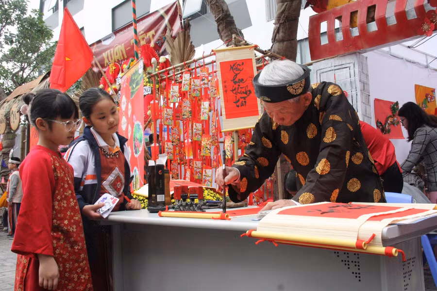 Học sinh xem ông Đồ viết chữ trong lễ hội Xuân.
