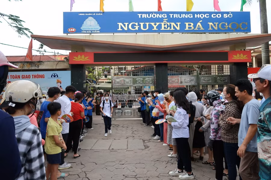 Người thân của các thí sinh và lực lượng thanh niên tình nguyện vỗ tay chúc mừng thí sinh hoàn thành môn thi đầu tiên.