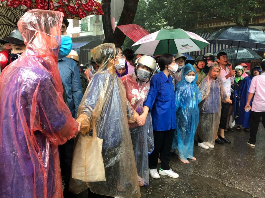 Dù mưa nhưng phụ huynh vẫn đứng ngóng con trước cổng trường thi.