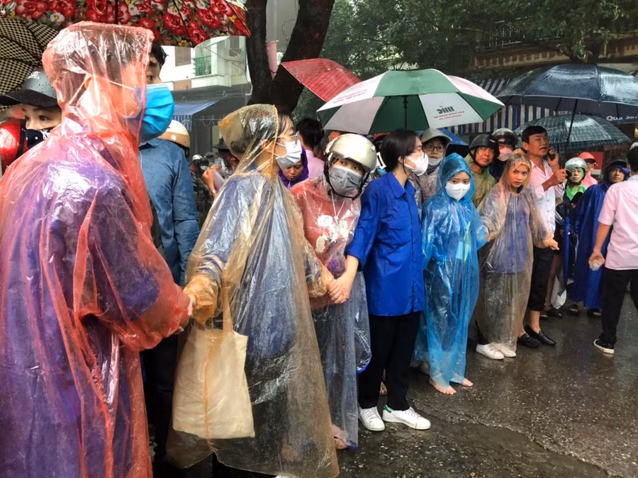 Dù mưa nhưng phụ huynh vẫn đứng ngóng con trước cổng trường thi.