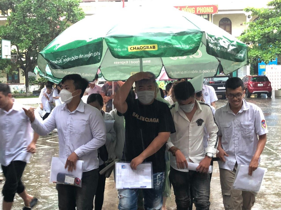 Thí sinh tại Điểm thi THPT Lê Hồng Phong đội mưa vào phòng thi