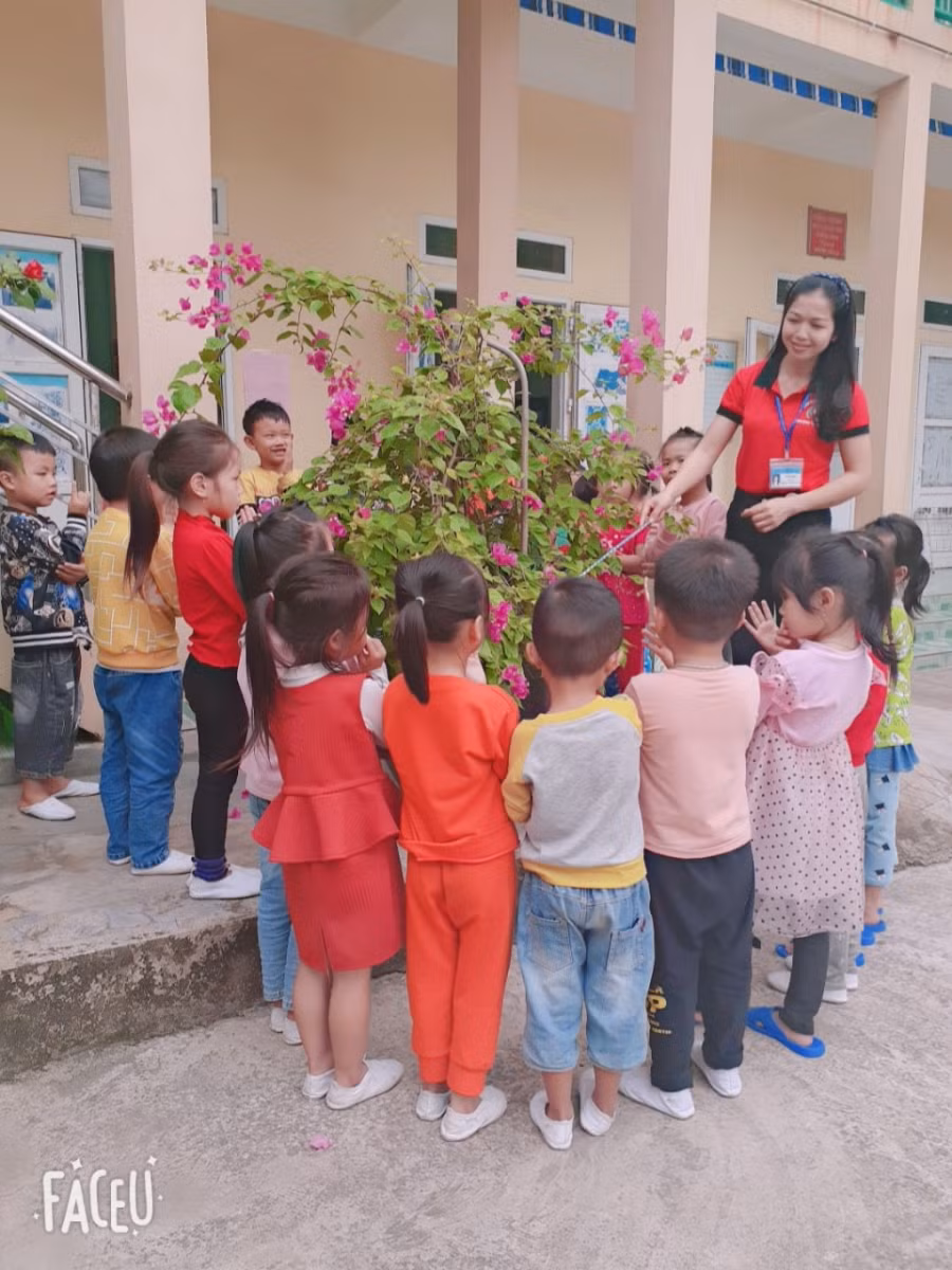 Cô Ngọc hướng dẫn trẻ tìm hiểu về môi trường tự nhiên xung quanh sân trường