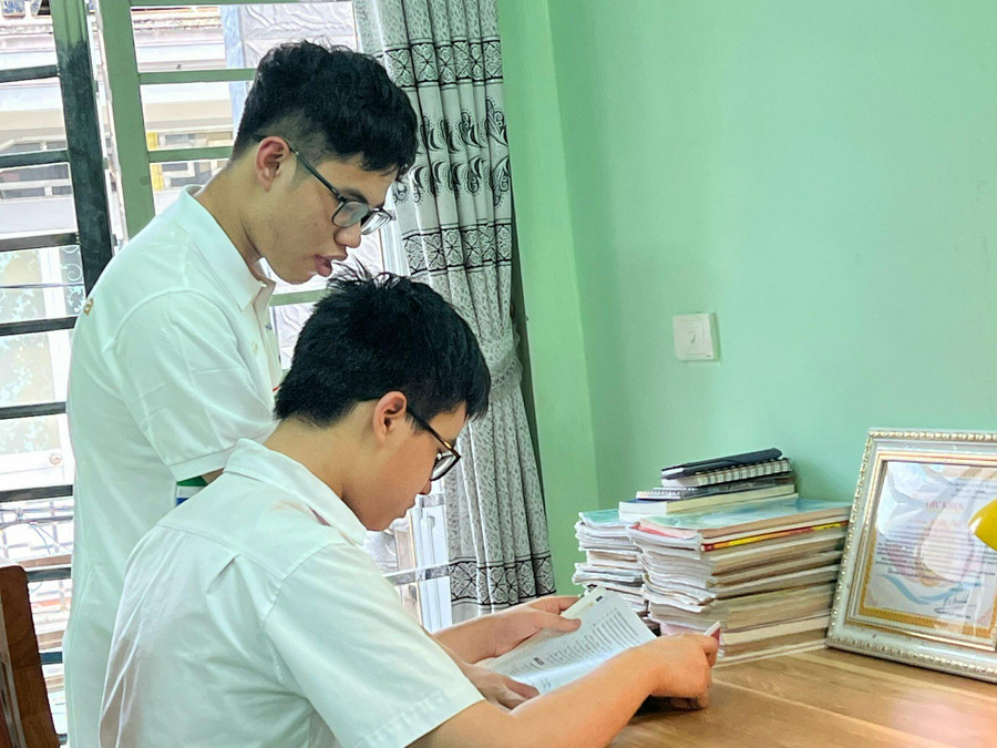 Tùng trao đổi bài với em trai. Ảnh: ND Tùng trao đổi bài với em trai. Ảnh: ND