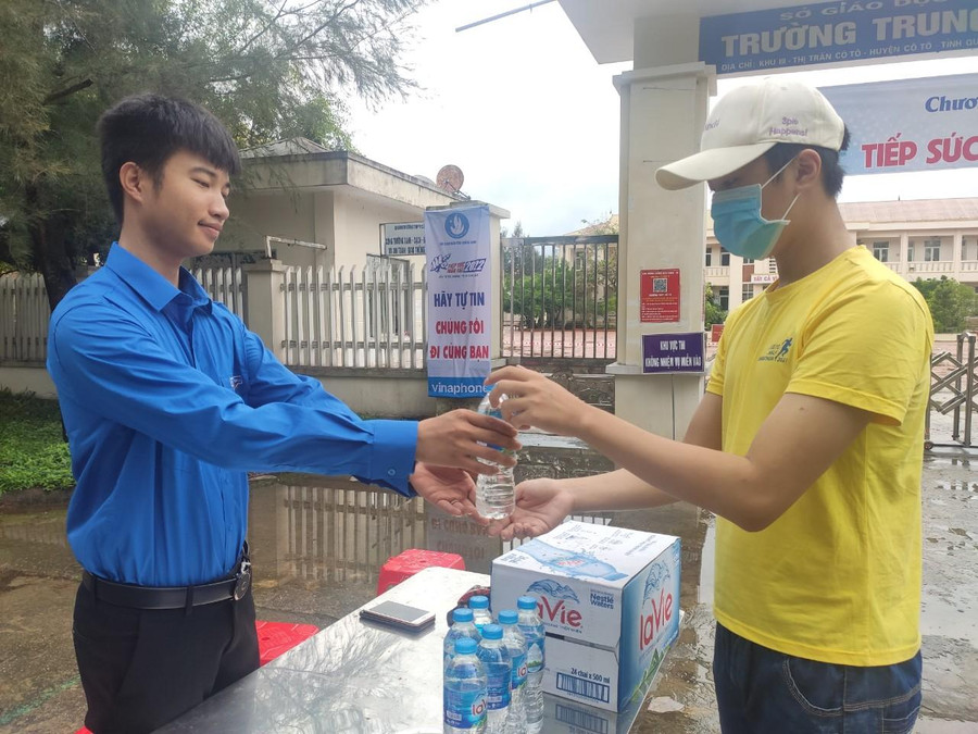 Sáng sớm ngày 8/7, tranh thủ cơn mưa ngưng tạnh, thanh niên tình nguyện tại Điểm thi THPT Cô Tô đón tiếp thí sinh.