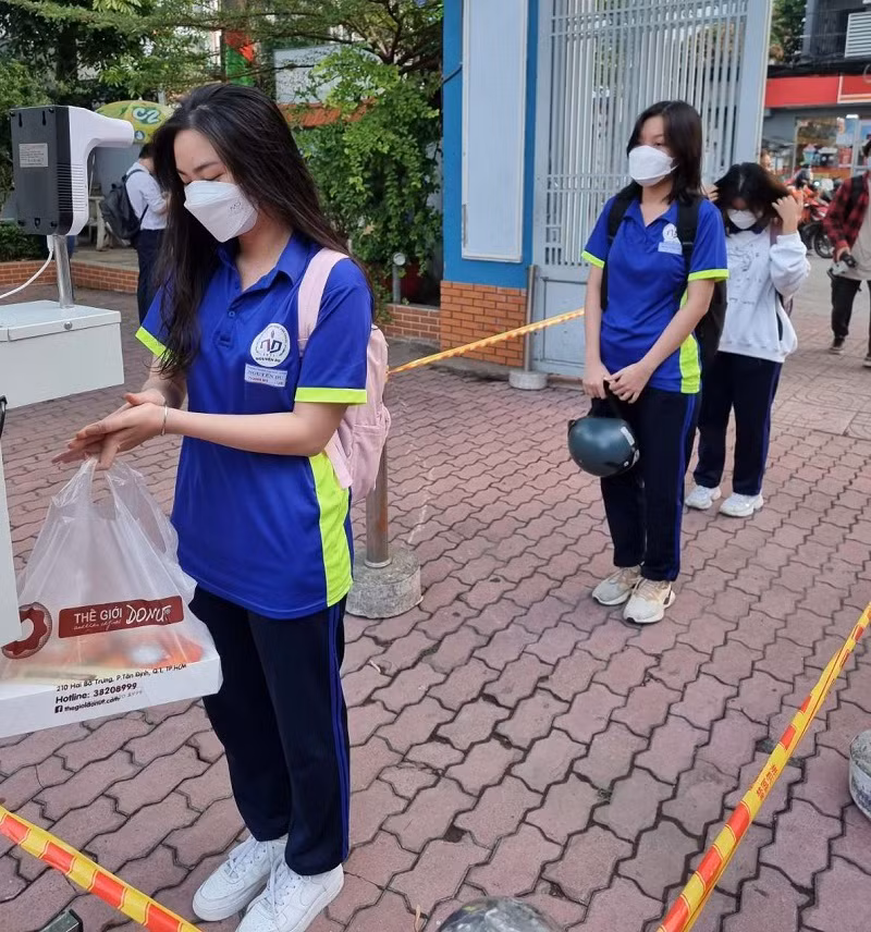 HS Trường THPT Nguyễn Du, Quận 10, TPHCM sát khuẩn tay trước khi vào trường.