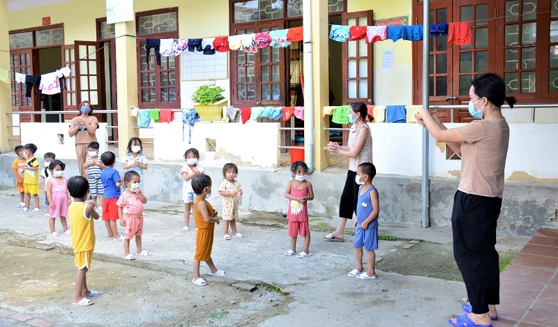 Giáo viên Trường Mầm non số 2 Mường Pồn cách ly cùng các em học sinh, tổ chức cho các em vận động nhẹ nhàng ngoài trời để nâng cao sức khỏe.