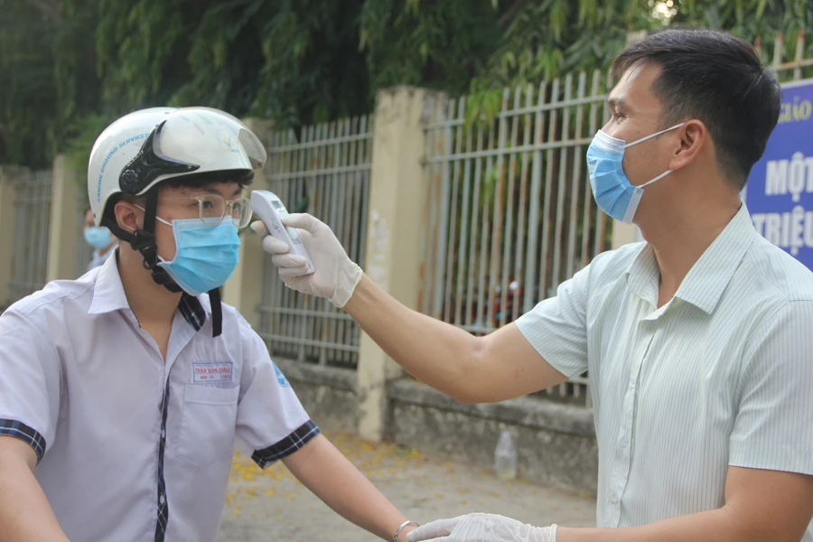 Học sinh được kiểm tra thân nhiệt trước khi vào trường. Ảnh minh hoạ 