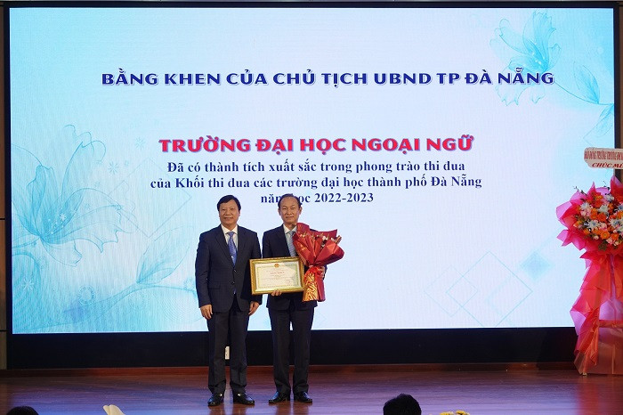 PGS.TS Lê Quang Sơn (bìa trái), Phó GĐ ĐH Đà Nẵng thừa ủy quyền trao Bằng khen của Chủ tịch UBND TP Đà Nẵng cho tập thể Trường ĐH Ngoại ngữ.