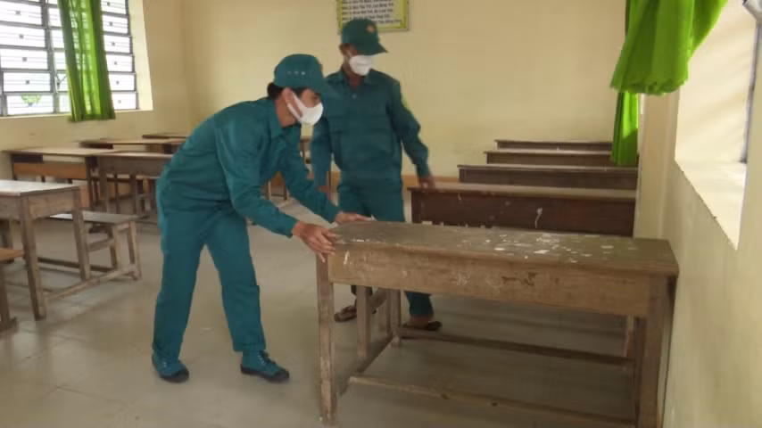 Lực lượng dân quân sắp xếp lại bàn ghế tại Trường THCS thị trấn Tân Trụ, huyện Tân Trụ, Long An sau thời gian được trưng dụng làm khu cách ly phòng dịch Covid-19. Ảnh: Kim Tuyền