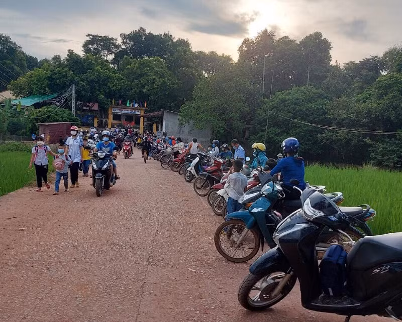 Phụ huynh được sắp xếp đứng đợi đón con trật tự tránh tập trung đông trước cổng trường. Ảnh: NTCC