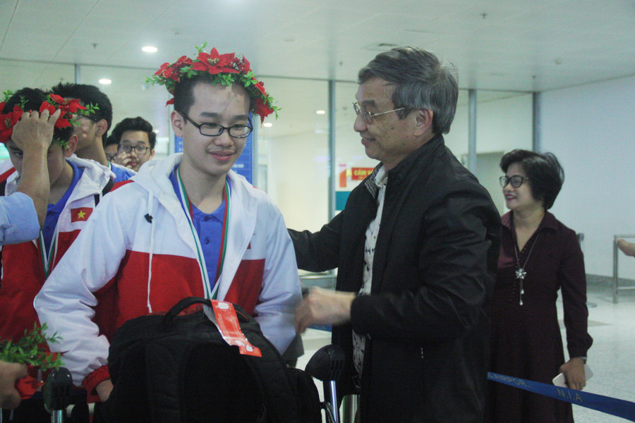 Đại diện lãnh đạo quận Ba Đình, ông Nguyễn Quang Trung - Phó Chủ tịch UBND quận ra sân bay, đeo vòng nguyệt quế cho học sinh Giảng Võ "chiến thắng" trở về