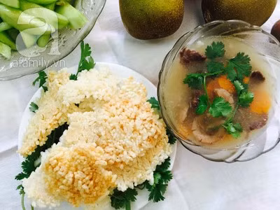 Bày cơm cháy và nước sốt ra, cho thêm một chút rau mùi, hạt tiêu lên bát nước sốt tim cật và thưởng thức.