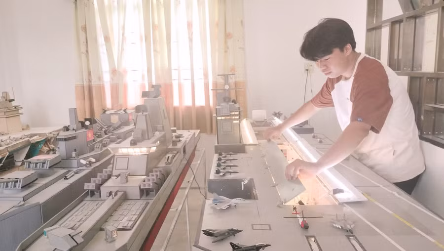 Trịnh Tuấn Kiệt bên bộ sưu tập mô hình tàu quân sự.