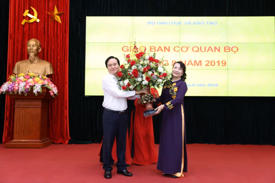 Bộ trưởng Bộ GD&ĐT Phùng Xuân Nhạ tặng hoa Thứ trưởng Nguyễn Thị Nghĩa trong lễ chia tay
