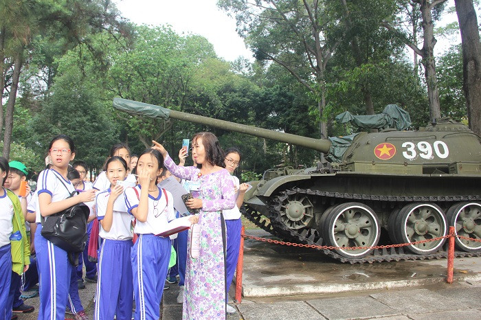 Thuyết minh viên đang chỉ dẫn cho các em học sinh