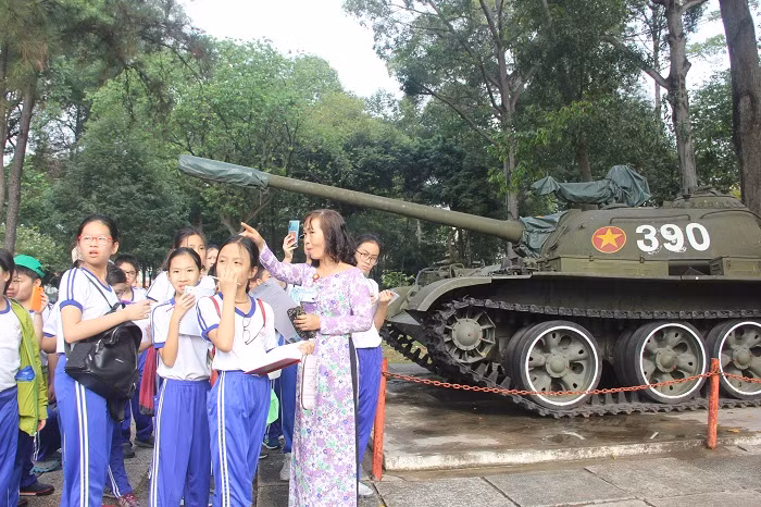 Thuyết minh viên đang chỉ dẫn cho các em học sinh