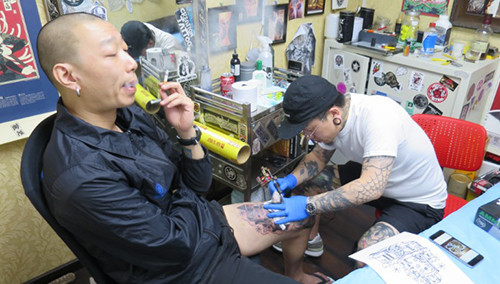 He Wei, một nhà thiết kế tự do 37 tuổi ở Bắc Kinh, đang được xăm hình tại Creation Tattoo