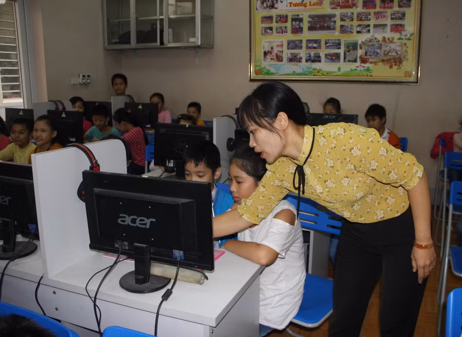 Do thiếu máy tính khi dạy học bộ môn Tin học nên nhiều trường phải áp dụng 2 học sinh/máy. Ảnh minh họa: Sỹ Điền