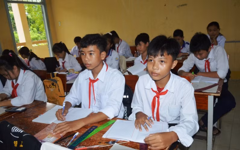 Em Thái Trọng Nhân (ngồi giữa, hàng đầu) trở về từ Campuchia đã hoàn thành cách ly và đi học cùng các bạn.