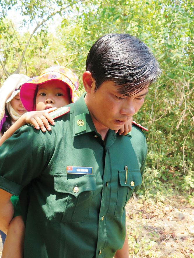 Sau giờ học, thầy giáo Biên phòng lại cõng các em về nhà dưới ghềnh sát biển. Ảnh: Tiền phong Sau giờ học, thầy giáo Biên phòng lại cõng các em về nhà dưới ghềnh sát biển. Ảnh: Tiền phong