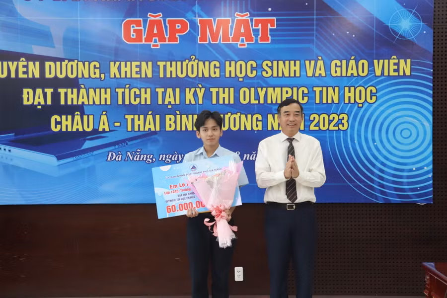 Ông Lê Trung Chính, Chủ tịch UBND TP Đà Nẵng tặng hoa chúc mừng em Lê Ngọc Bảo Anh (bên trái). 