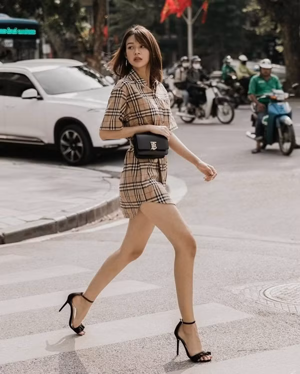 Phí Phương Anh đầy sang chảnh thời thượng với bộ cánh họa tiết kẻ kinh điển của thương hiệu Burberry mix cùng sandals cao gót tôn dáng. Để giúp set đồ thêm phần đắt giá, cô nàng sử dụng phụ kiện là chiếc túi hàng hiệu đi kèm.
