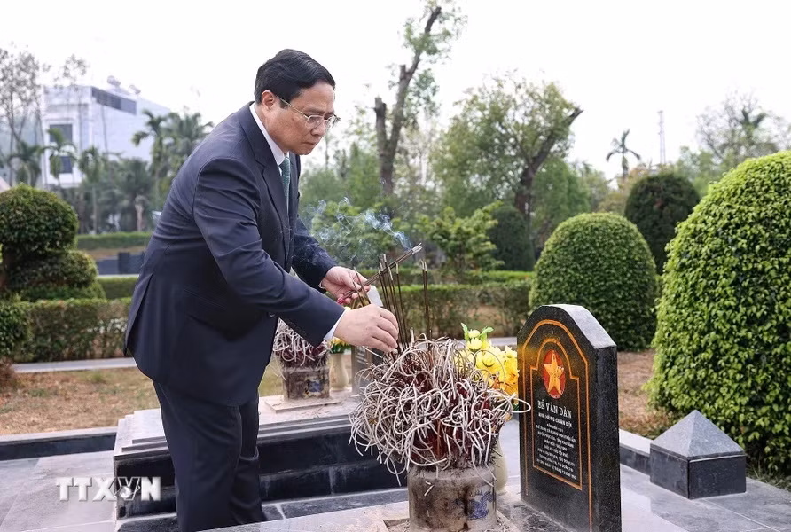 Thủ tướng Phạm Minh Chính thắp hương tại mộ phần các liệt sỹ. (Ảnh: Dương Giang/TTXVN)