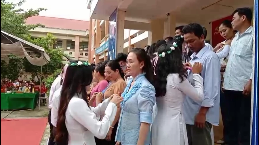 Các em học sinh lớp 12 cài hoa tri ân cha mẹ.