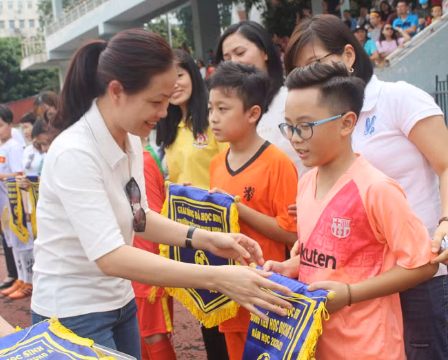 Cô Ngô Thị Bích Thủy - Hiệu trưởng trường Tiểu học Dịch Vọng A tặng quà và cờ lưu niệm cho các đội bóng tham gia giải đấu.