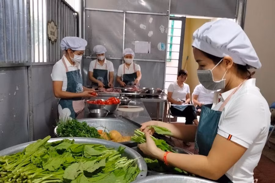 Nhân viên nuôi dưỡng làm việc trong bếp ăn. Ảnh minh họa: TG